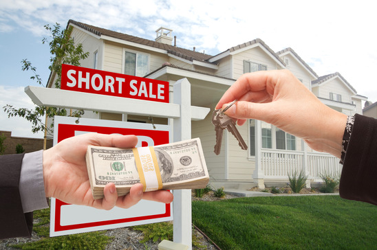 Handing Over Cash For House Keys and Short Sale Real Estate Sign in Front of Home.